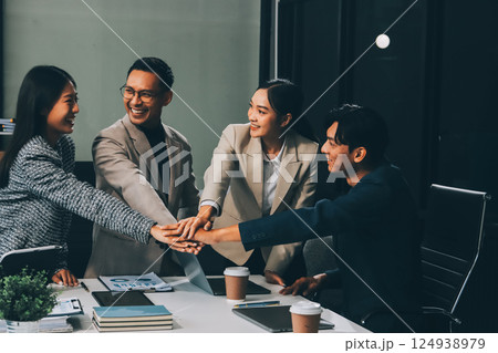Business team showing unity with their hands together, Close up top view of young business people putting their hands together. people together to work as team to ensure the success of the business Business team showing unity with their hands together, Close up top view of young business people putting their hands together. people together to work as team to ensure the success of the business 124938979