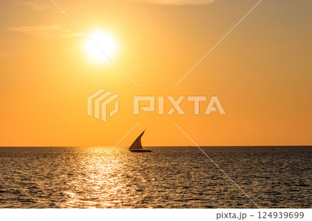 Silhouette of traditional wooden dhow boat in the Indian ocean at sunset in Zanzibar, Tanzania Silhouette of traditional wooden dhow boat in the Indian ocean at sunset in Zanzibar, Tanzania 124939699