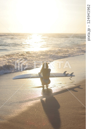 Surfing at Sunset A Beautiful and Serene Moment to Enjoy by the Oceans Edge, Embracing Nature 124941962