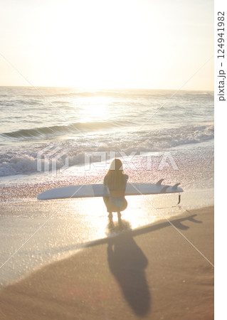Surfing at Sunset A Beautiful and Serene Moment to Enjoy by the Oceans Edge, Embracing Nature 124941982