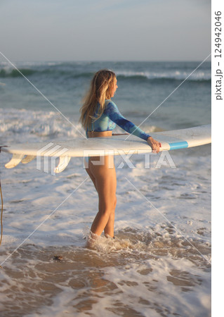 Enjoying Surfing at Sunset A Stylish, Skillful Wave Rider on the Beautiful Beach 124942046