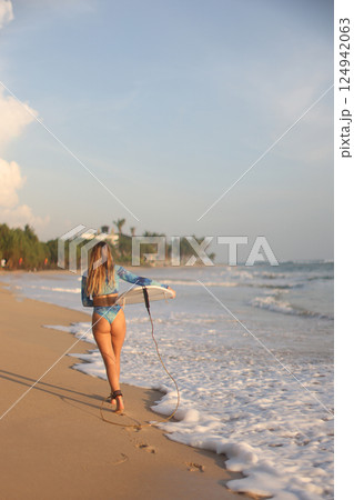 Enjoying Surfing at Sunset A Stylish, Skillful Wave Rider on the Beautiful Beach 124942063