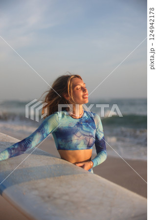 A Woman Fully Embracing the Relaxing Ocean Vibes While Enjoying the Beautiful Sunrise Moment A Woman Fully Embracing the Relaxing Ocean Vibes While Enjoying the Beautiful Sunrise Moment 124942178