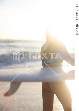 A Surfer Girl Happily Enjoying the Beautiful Sunset on the Beach by the Gentle Ocean Waves A Surfer Girl Happily Enjoying the Beautiful Sunset on the Beach by the Gentle Ocean Waves 124942214
