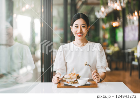 Asian woman healthy eating breakfast sandwich food diet meal at indoor cafe 124943272