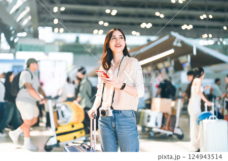 Portrait of standing tourist woman passenger at international airport terminal for holidays travel Portrait of standing tourist woman passenger at international airport terminal for holidays travel 124943514