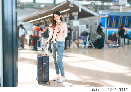Portrait of standing tourist woman passenger at international airport terminal for holidays travel Portrait of standing tourist woman passenger at international airport terminal for holidays travel 124943515