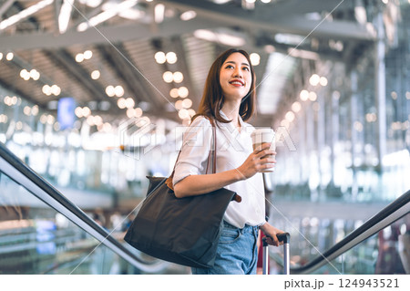 Adult passenger business asian woman with coffee cup and luggage at airport terminal for depature 124943521