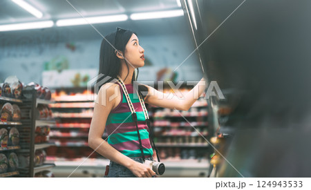 Asian woman consumer choosing food or seasoning product at supermarket store Asian woman consumer choosing food or seasoning product at supermarket store 124943533