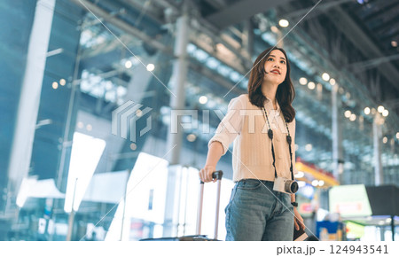 Portrait of standing tourist woman passenger at international airport terminal for holidays travel Portrait of standing tourist woman passenger at international airport terminal for holidays travel 124943541