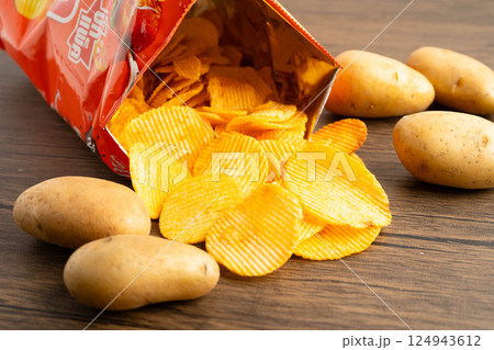 Bangkok, Thailand - May 15, 2022 Potato chips in open bag, delicious BBQ seasoning spicy for crips, thin slice deep fried snack fast food. Bangkok, Thailand - May 15, 2022 Potato chips in open bag, delicious BBQ seasoning spicy for crips, thin slice deep fried snack fast food. 124943612