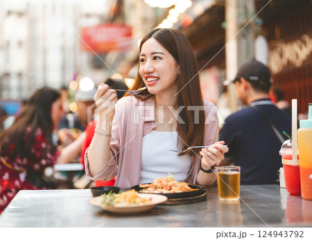 Traveler woman enjoy eating street food spicy menu travel at chinatown Yaowarat, Bangkok, Thailand Traveler woman enjoy eating street food spicy menu travel at chinatown Yaowarat, Bangkok, Thailand 124943792
