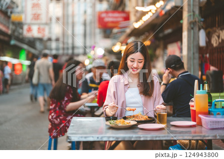 Adult travel woman enjoy eating street food spicy menu travel at chinatown Yaowarat Bangkok Thailand 124943800