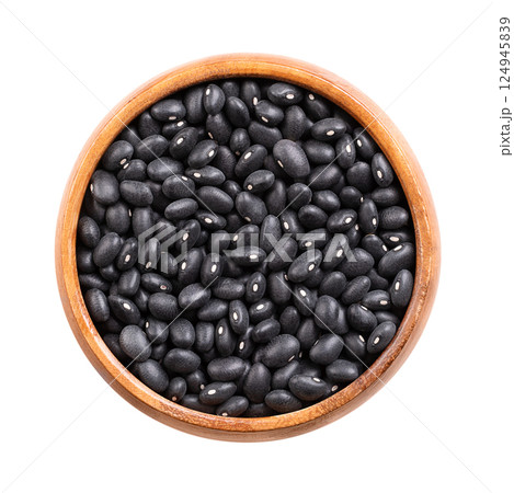 Black beans in a wooden bowl. Dried variety of common beans, Phaseolus vulgaris, also known as black turtle beans, and caviar criollo. A type of bean with satiny black skin and a white center. Photo 124945839