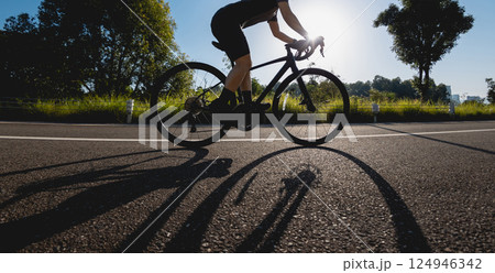 Woman cycling on summer park trail 124946342