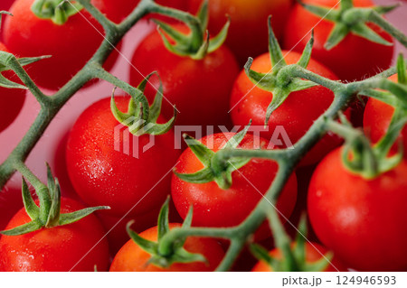 Fresh red cherry tomato on red background. Fresh red cherry tomato on red background. 124946593