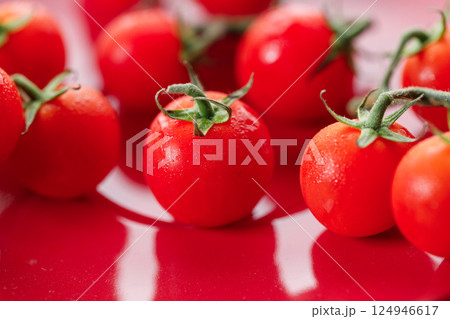 Fresh red cherry tomato on red background. 124946617
