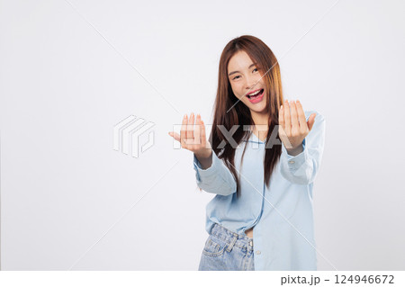 Woman uses hand gesture to beckon come here, while another woman stands with palm extended in a welcoming pose, cheerful expressions isolated in white studio background. Woman uses hand gesture to beckon come here, while another woman stands with palm extended in a welcoming pose, cheerful expressions isolated in white studio background. 124946672