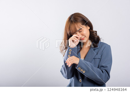 Asian woman, seen in studio setting, wipes away tears with her fingers, depicting intense sadness, frustration, and despair. Isolated on white, expressive face reveals dramatic tale emotional struggle Asian woman, seen in studio setting, wipes away tears with her fingers, depicting intense sadness, frustration, and despair. Isolated on white, expressive face reveals dramatic tale emotional struggle 124948164