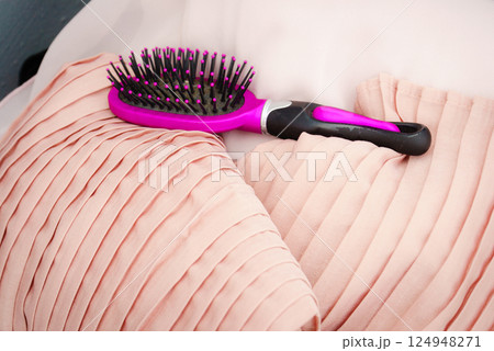 Black and purple hair brush on pink pillows Black and purple hair brush on pink pillows 124948271