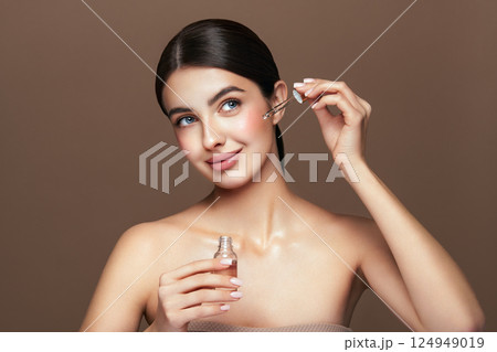 Young beautiful woman applying face serum Young beautiful woman applying face serum 124949019