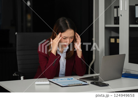 Serious businesswoman concentrating on his paper work at the table at office. 124949658