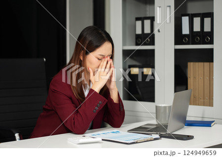 Serious businesswoman concentrating on his paper work at the table at office. 124949659