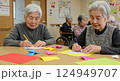施設で折り紙をおっている老人女性たち 124949707