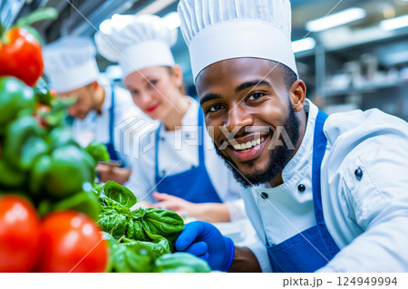 A group of chefs working in a kitchen preparing food together A group of chefs working in a kitchen preparing food together 124949994