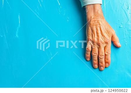 A person's hand on a blue wall 124950022
