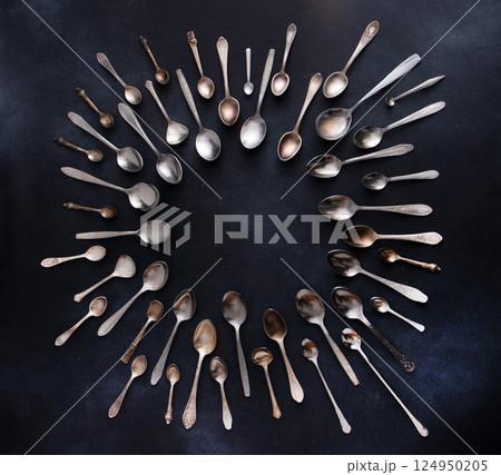Set of different spoons. Silver cutlery on a black background. Spoon on the table Set of different spoons. Silver cutlery on a black background. Spoon on the table 124950205