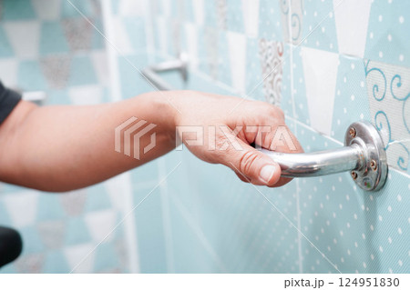 Asian woman patient use toilet support rail in bathroom, handrail safety grab bar, security in nursing hospital. 124951830