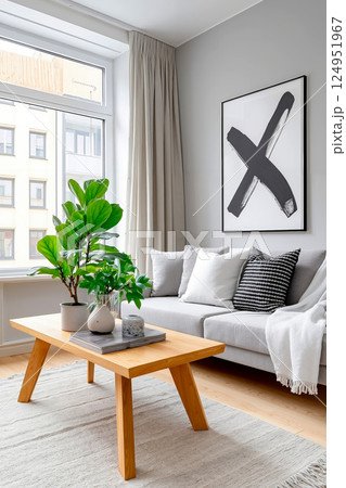 A living room with a couch, coffee table and a plant in a pot 124951967