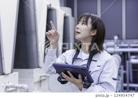 ビルの屋上で点検作業をする若い女性作業員　撮影協力：学校法人電波学園 東京電子専門学校 124954747