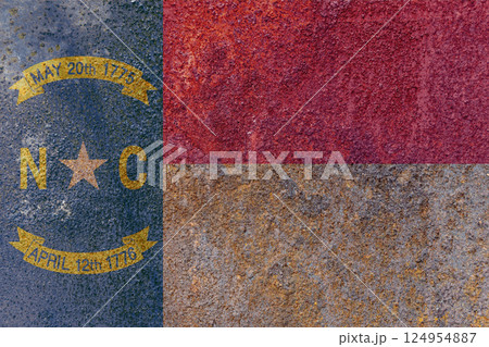 North Carolina State Flag. Dirty North Carolina state flag on rusty metal surface. 124954887