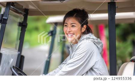 ゴルフ場のゴルフカートに乗る女性 124955336
