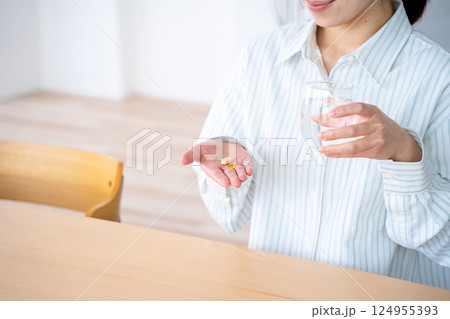 薬を飲む若い女性 124955393