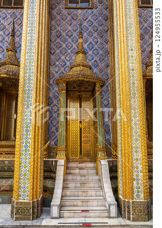 Colorful golden temple entrance with ornate tiled columns and stairs in traditional Thai architectural style Colorful golden temple entrance with ornate tiled columns and stairs in traditional Thai architectural style 124955533