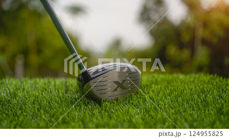 Golf clubs on a green lawn in a beautiful golf course with morning sunshine. 124955825