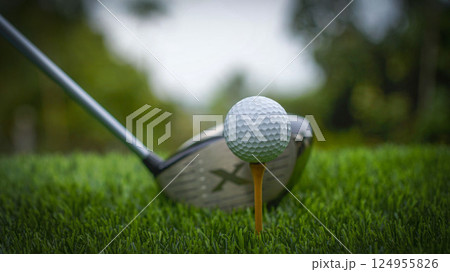 Golf clubs and balls on a green lawn in a beautiful golf course with morning sunshine. 124955826