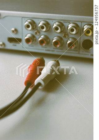 Rear panel of a multimedia player with ejected plugs on video cable in old film style Rear panel of a multimedia player with ejected plugs on video cable in old film style 124956737