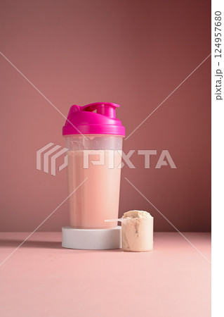 Pink, strawberry protein drink in a pink shaker, food supplement concept Pink, strawberry protein drink in a pink shaker, food supplement concept 124957680