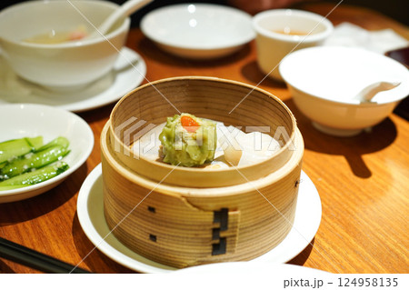 飲茶レストランの蒸籠に入ったほうれん草の焼売と小籠包 飲茶レストランの蒸籠に入ったほうれん草の焼売と小籠包 124958135