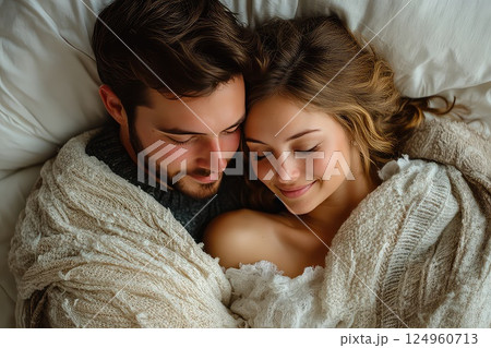 Close up of a young loving heterosexual couple sweet sleeping embracing each other. The young couple sweetly sleeps together, their close embrace embodying comfort and deep emotional ties. 124960713