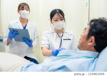 病棟で入院患者のバイタルチェックをする看護師の女性 124961009