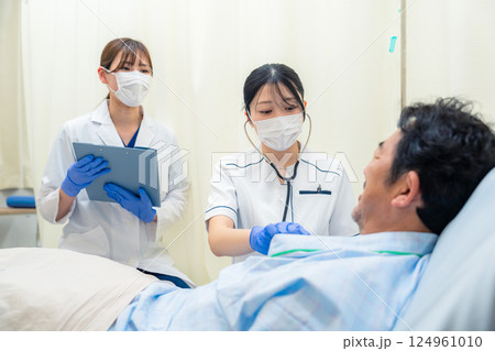 病棟で入院患者のバイタルチェックをする看護師の女性 124961010