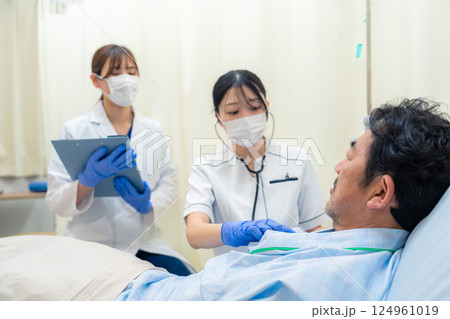 病棟で入院患者のバイタルチェックをする看護師の女性 124961019