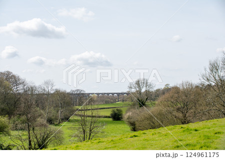 大木と緑に囲まれたレンガ造りの歴史的な高架橋　ロンドンから南の郊外にあるオウズ渓谷にて 124961175