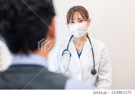 病院で男性患者の問診をする女性医師 病院で男性患者の問診をする女性医師 124961375