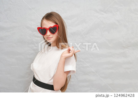 Young caucasian female with long hair and heart-shaped sunglasses posing 124962428